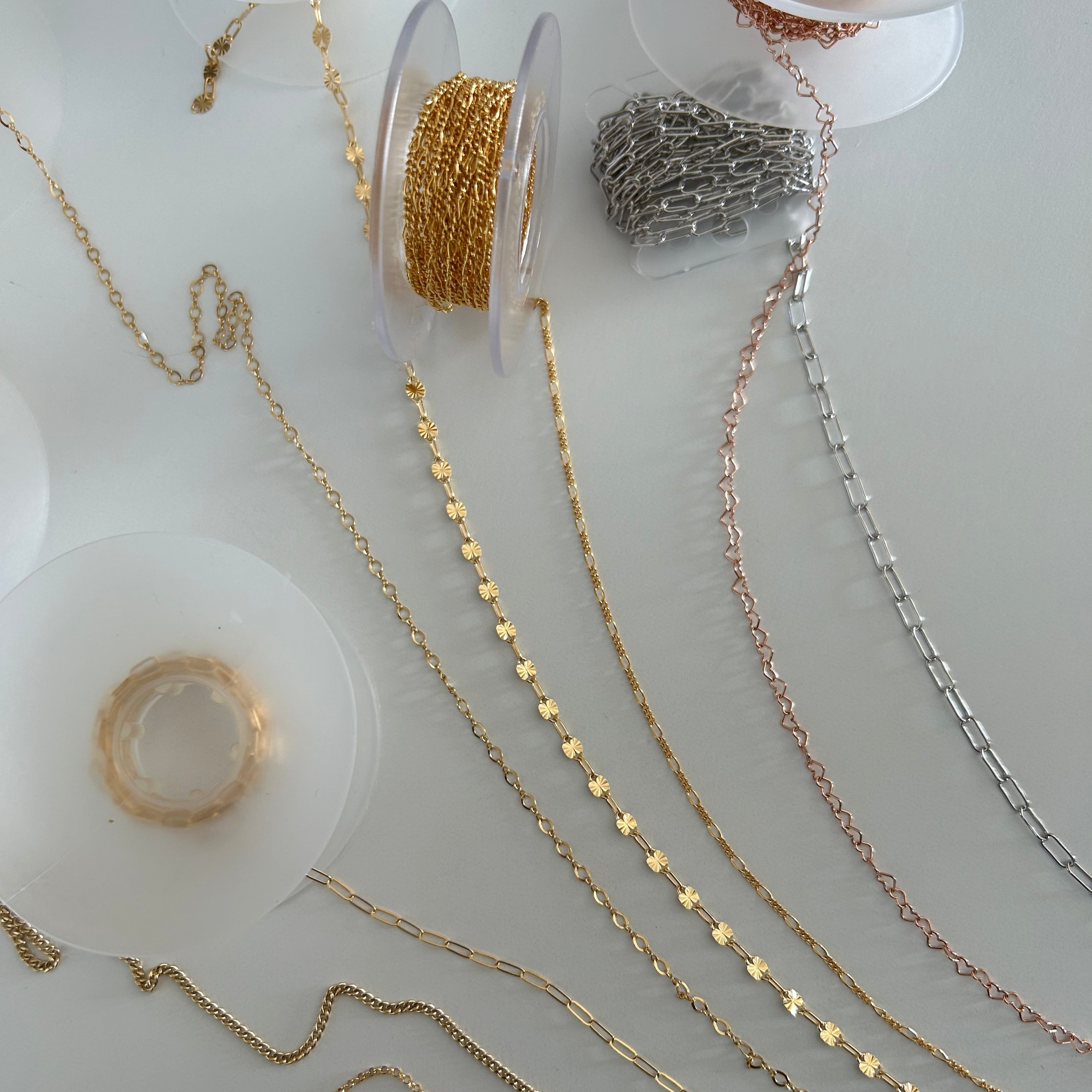 image of permanent jewelry chains on a white table