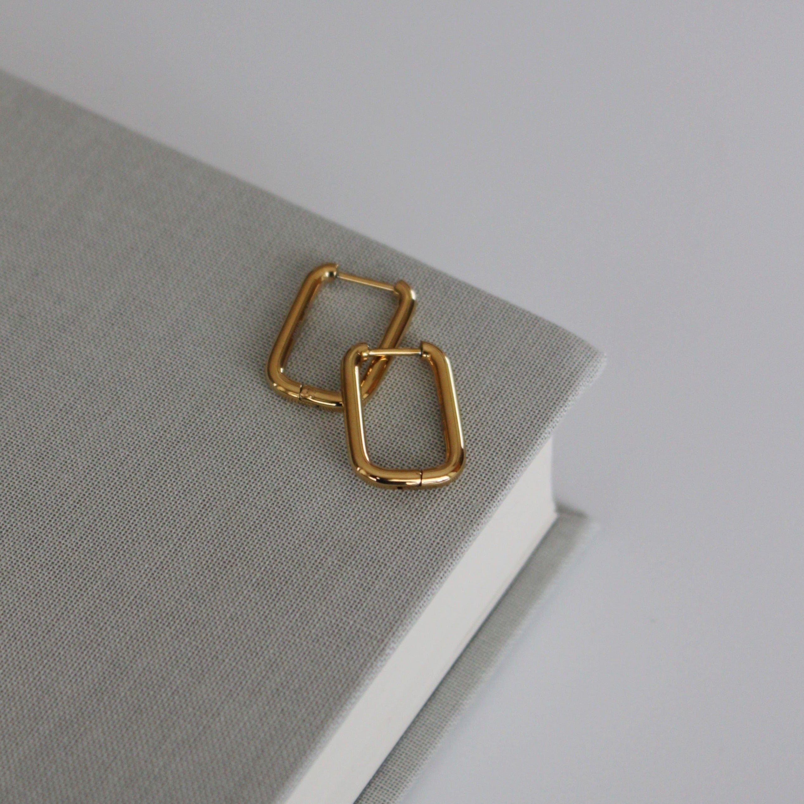 image of gold square hoops on top of a book
