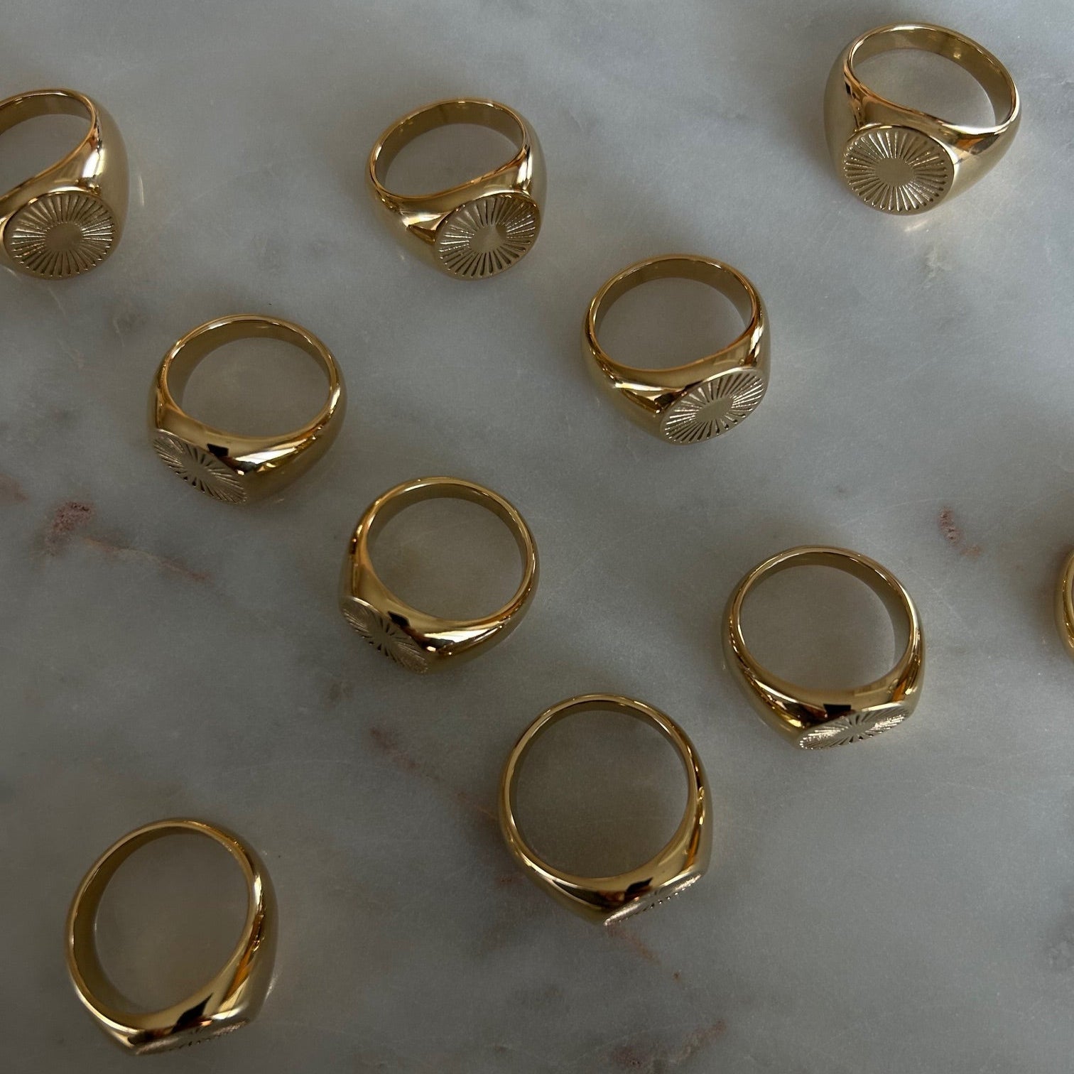image of gold signet rings on a marble table