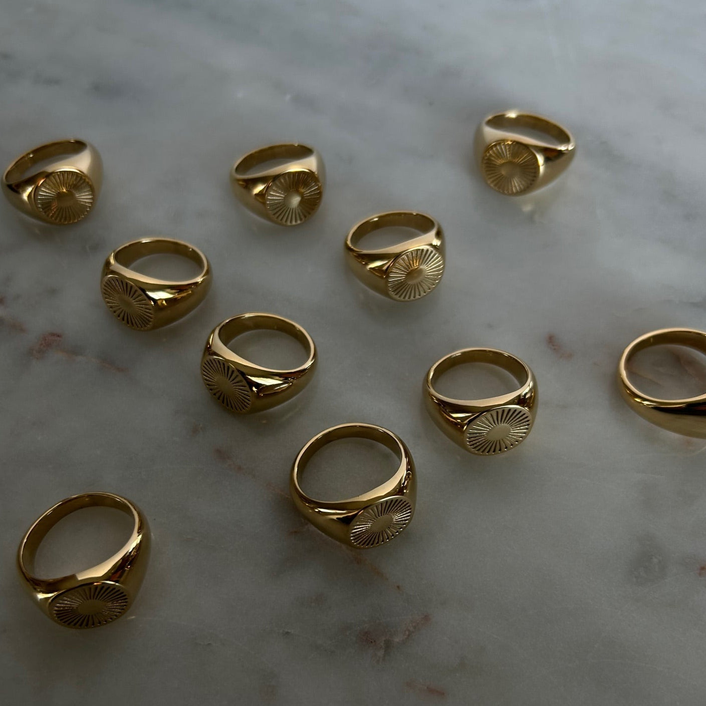 image of gold signet rings on a marble table