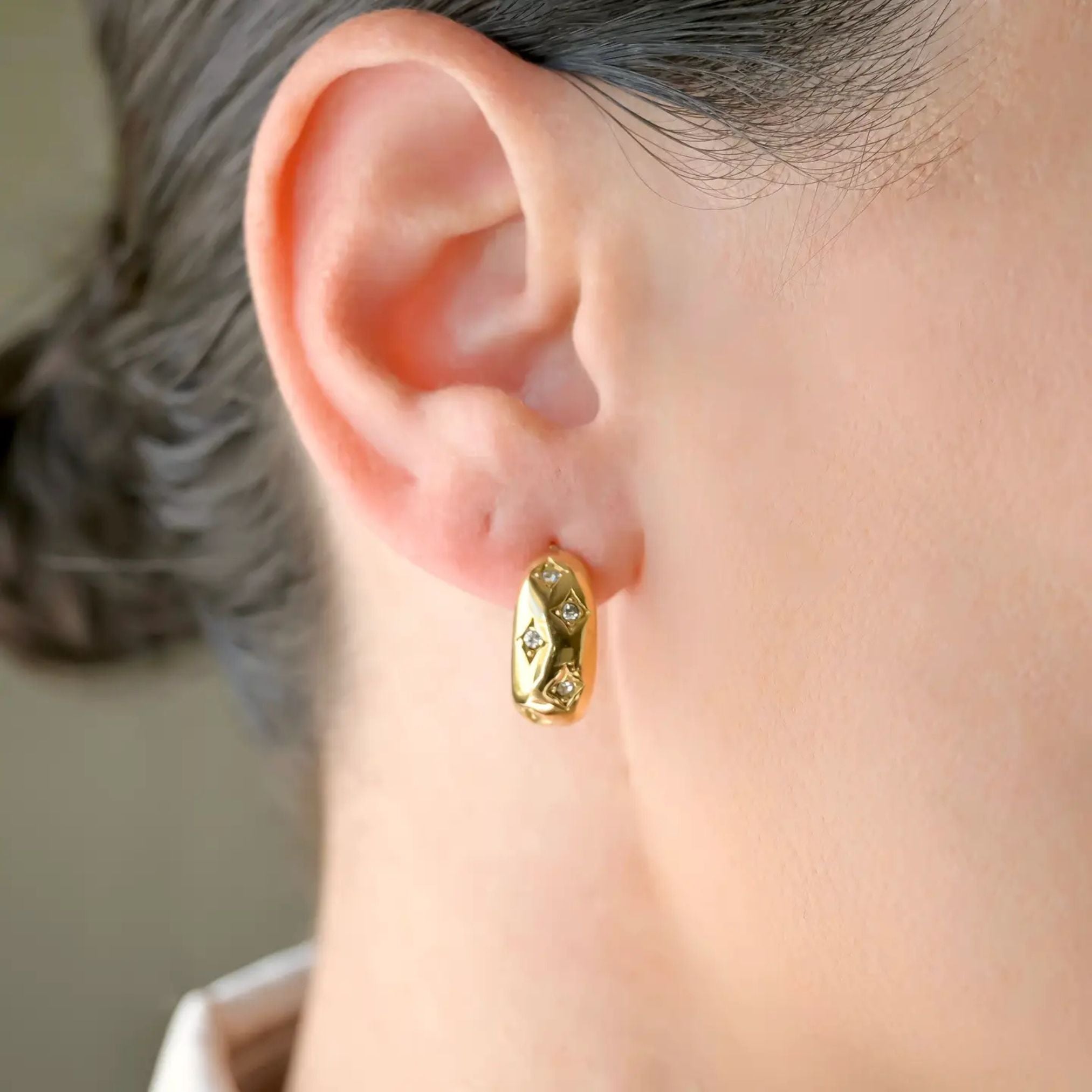 image of a woman wearing gold earrings