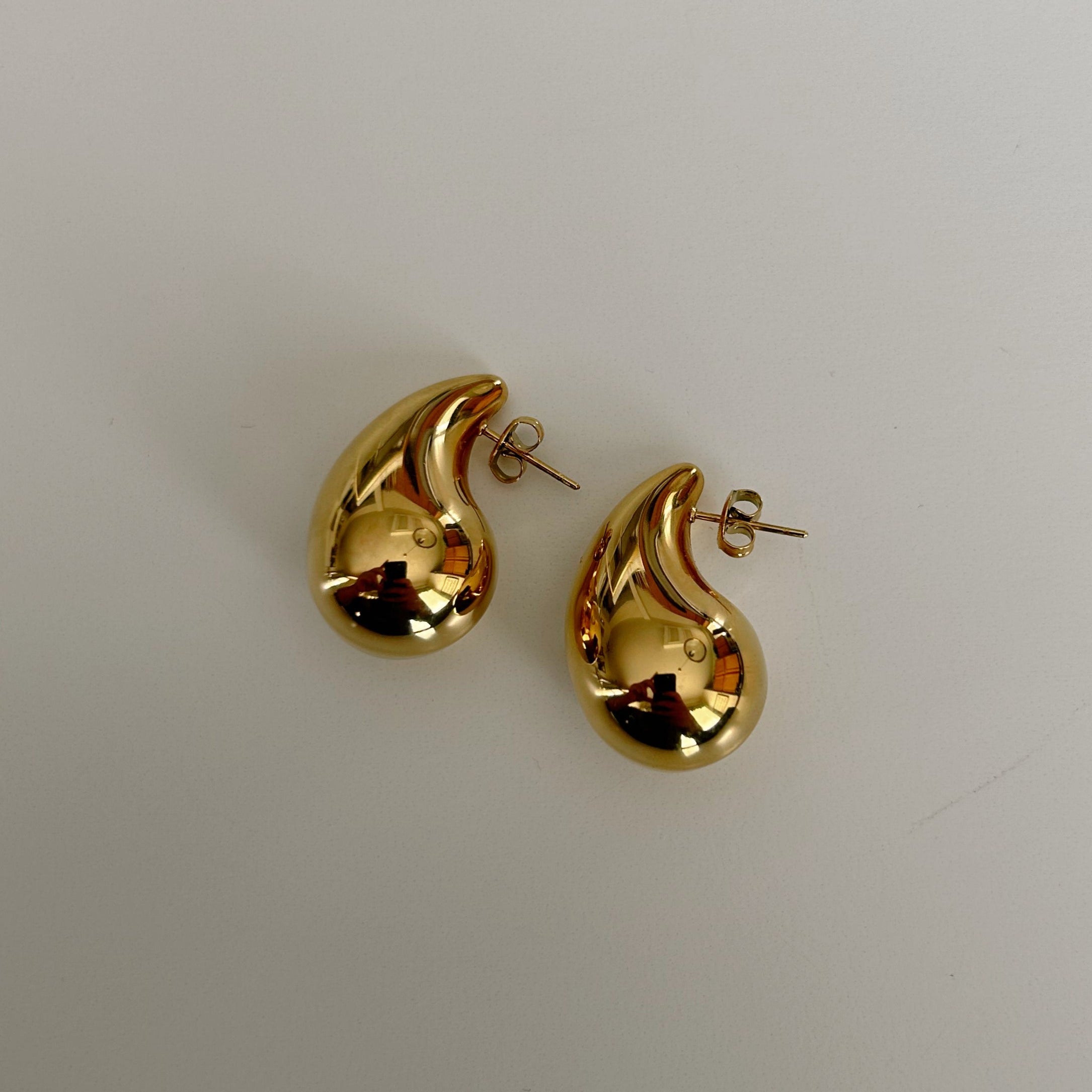 image of two teardrop earrings against a white backdrop