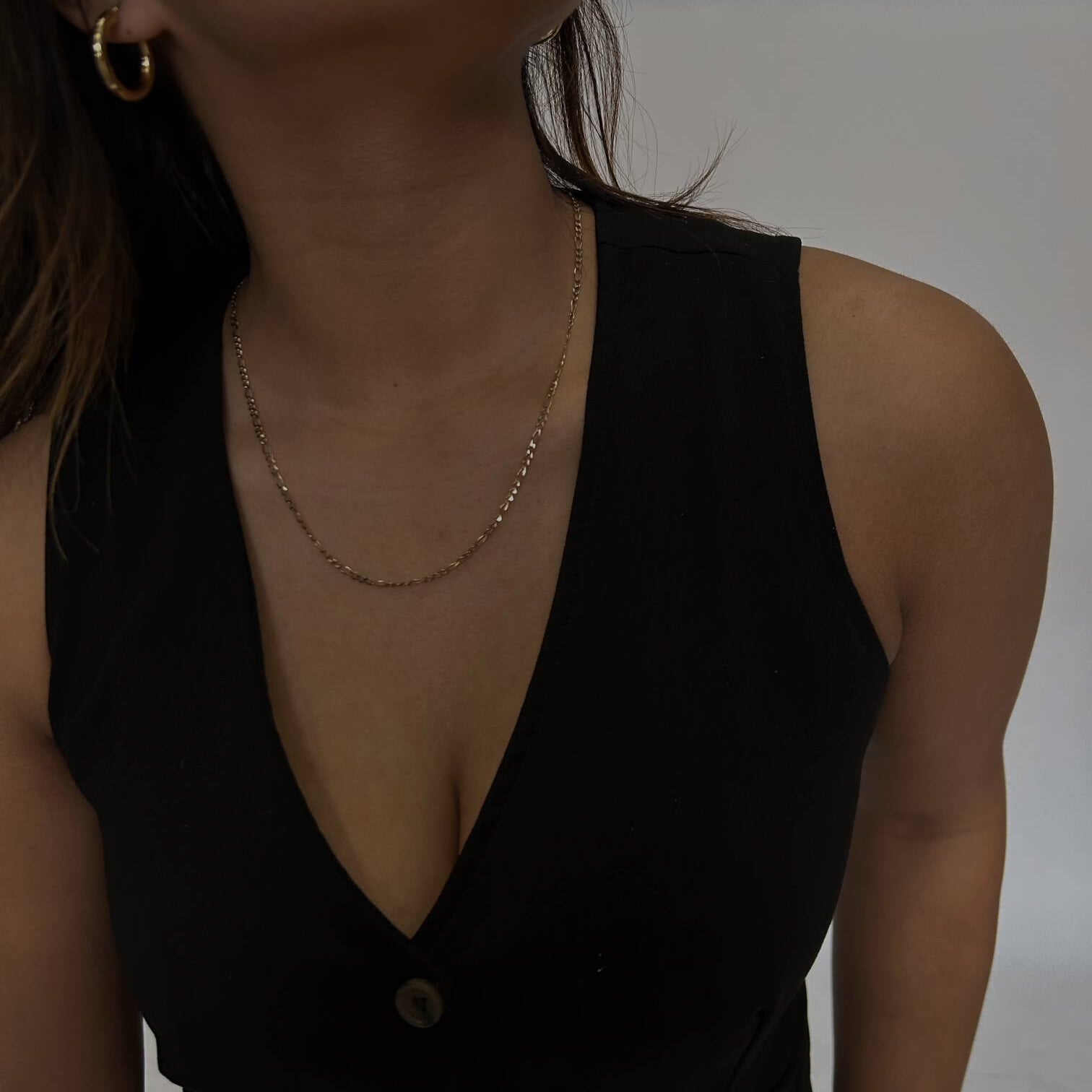 woman wearing gold figaro chain
