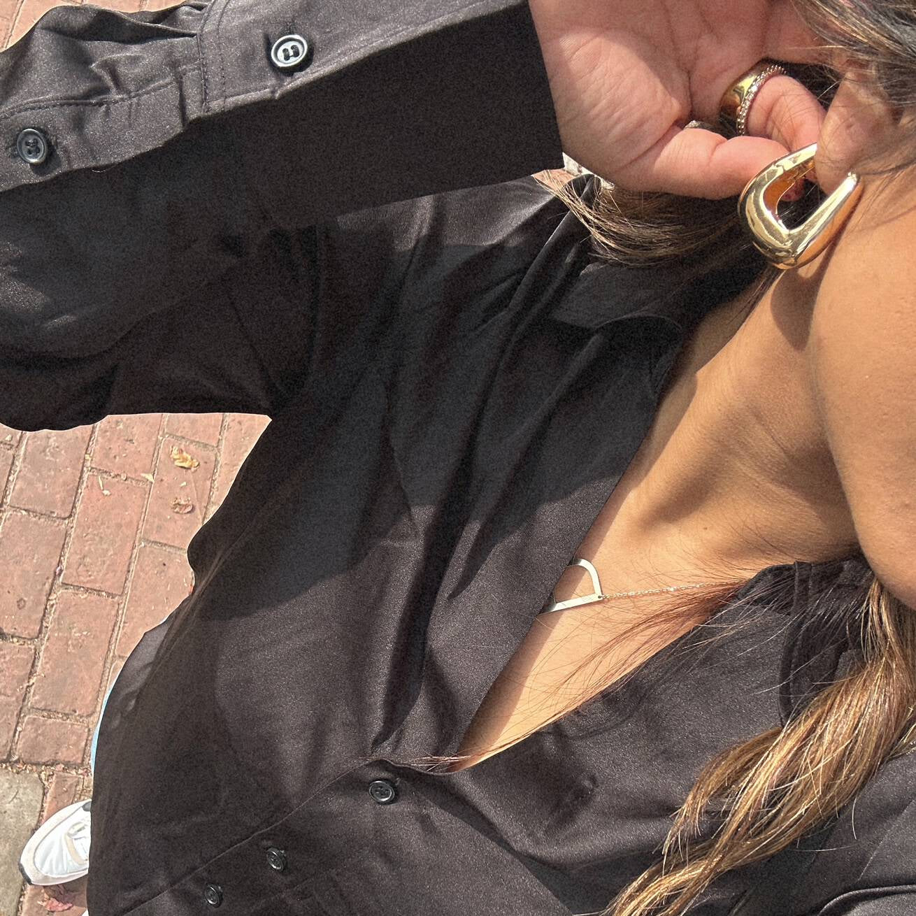 image of a woman wearing gold square hinged hoops