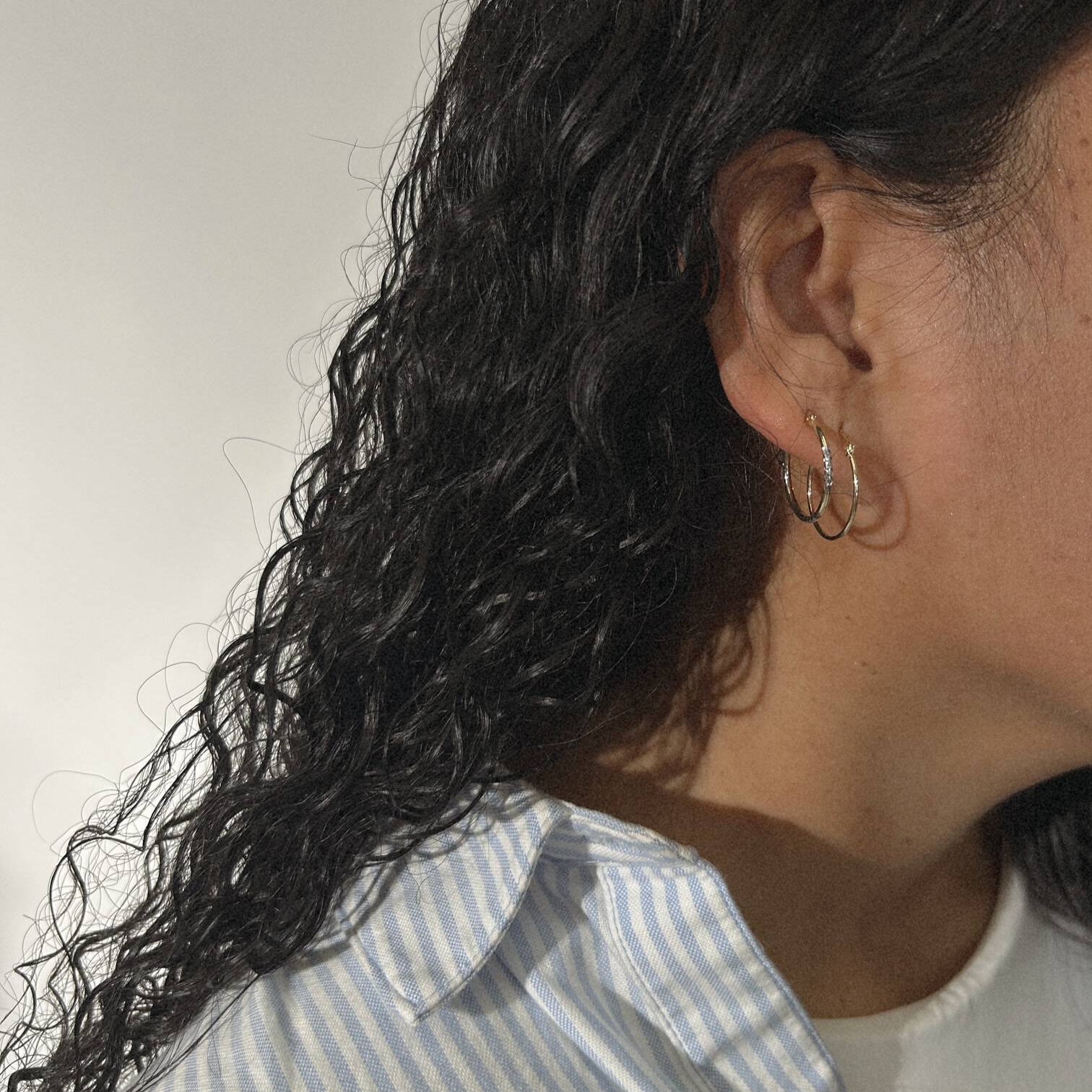 image of woman with two golden hoop earrings