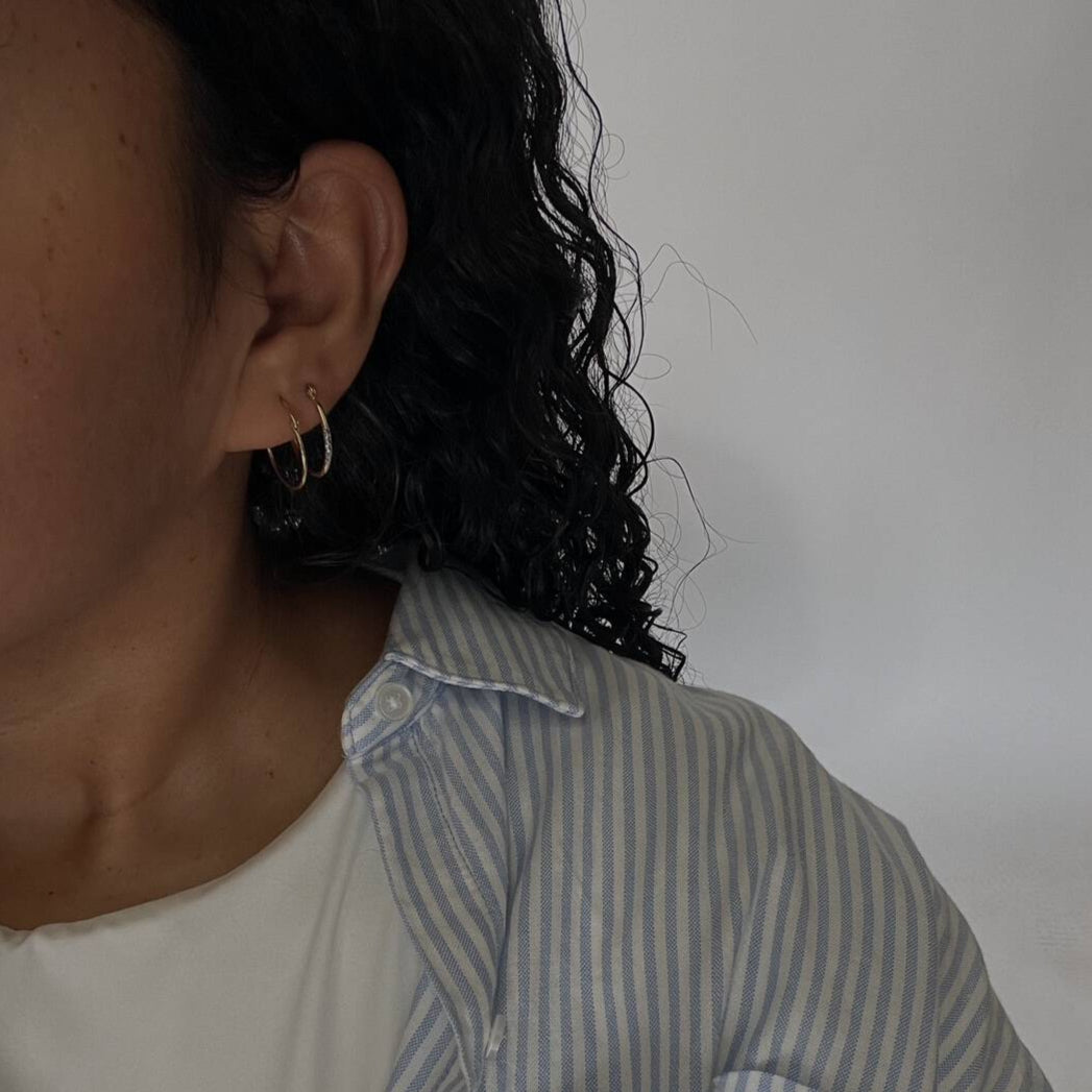 image of woman with two golden hoop earrings selfie
