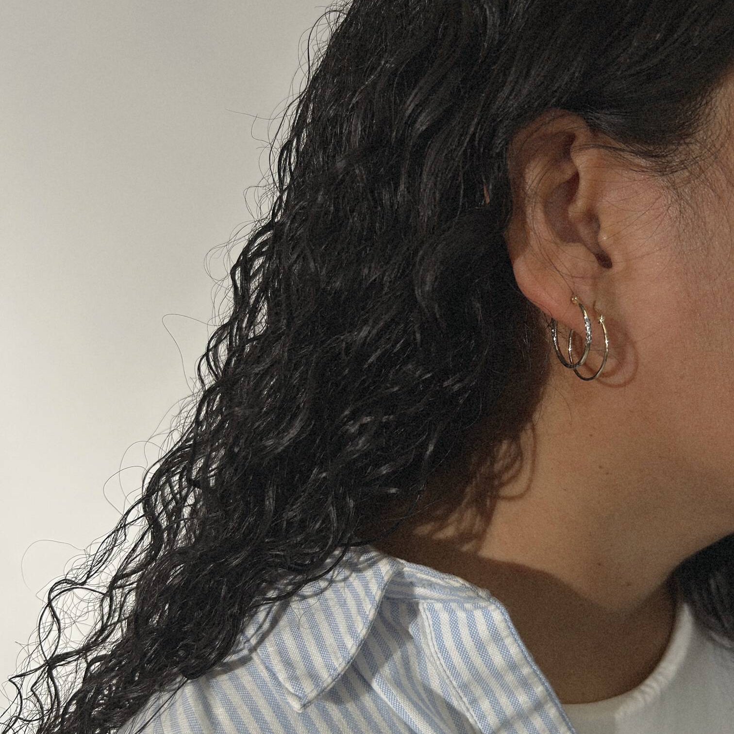 image of woman with two golden hoop earrings