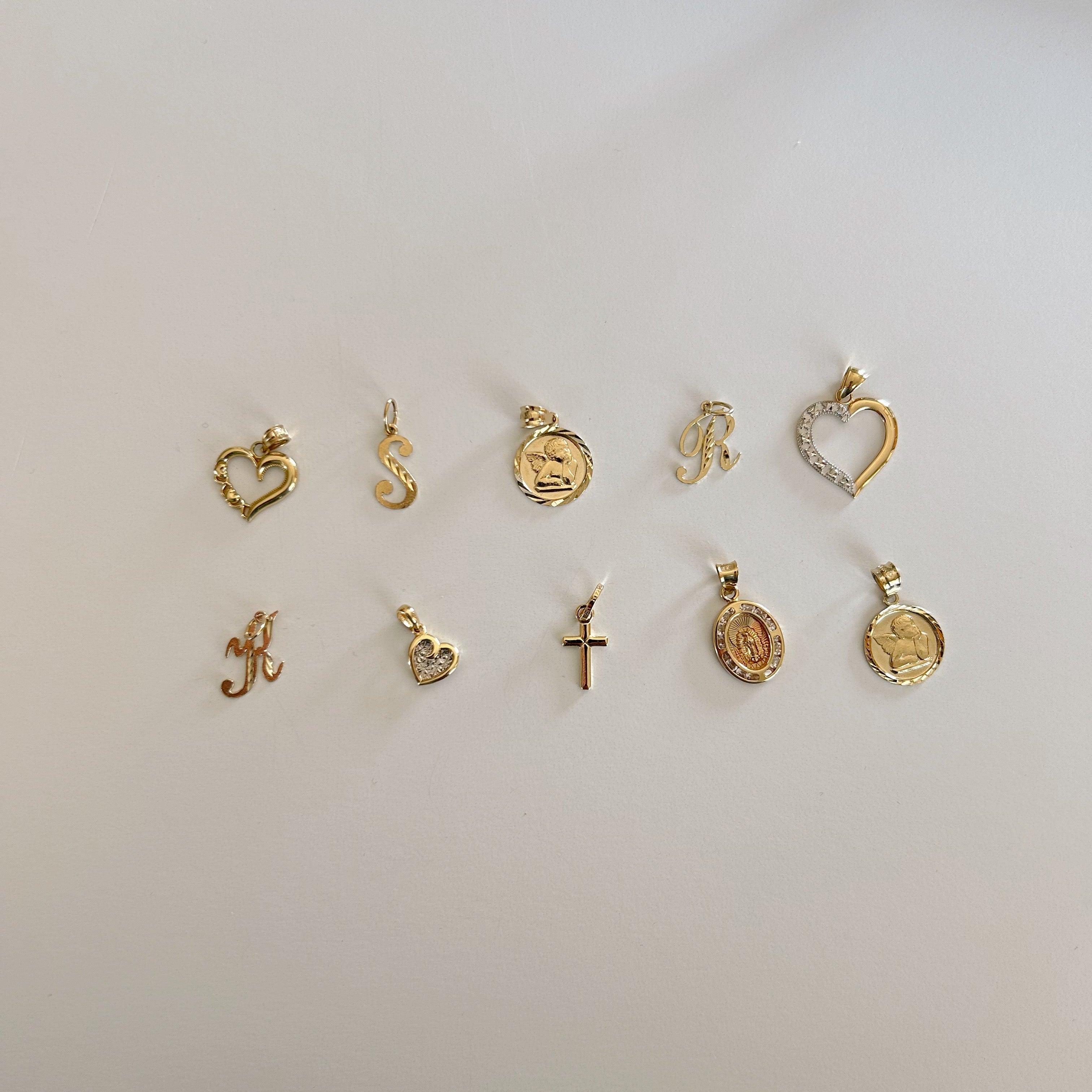 image of multiple gold charm pendants on a white backdrop