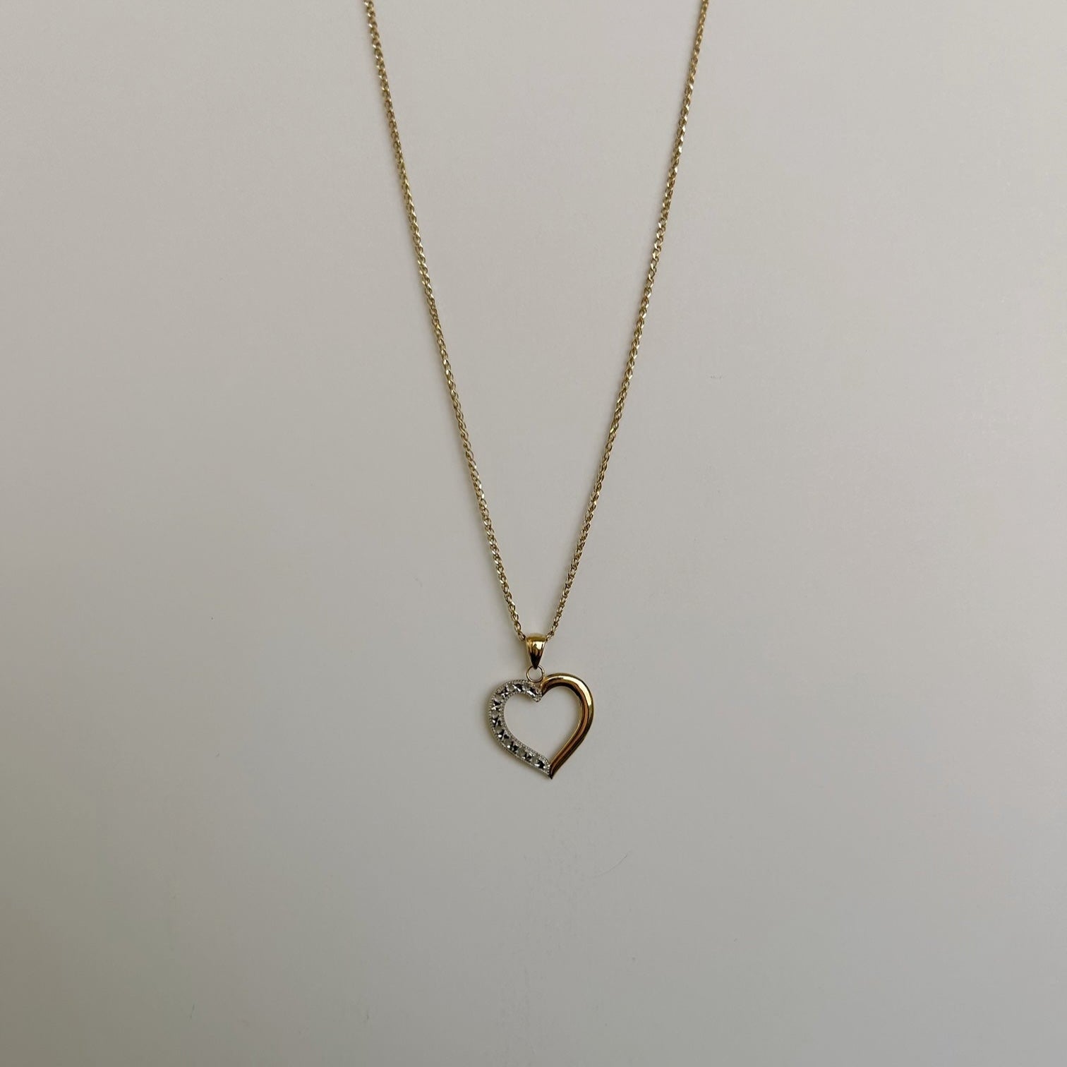 image of a two tone heart pendant and necklace on a white backdrop