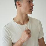 Person wearing a white tank top against a plain background