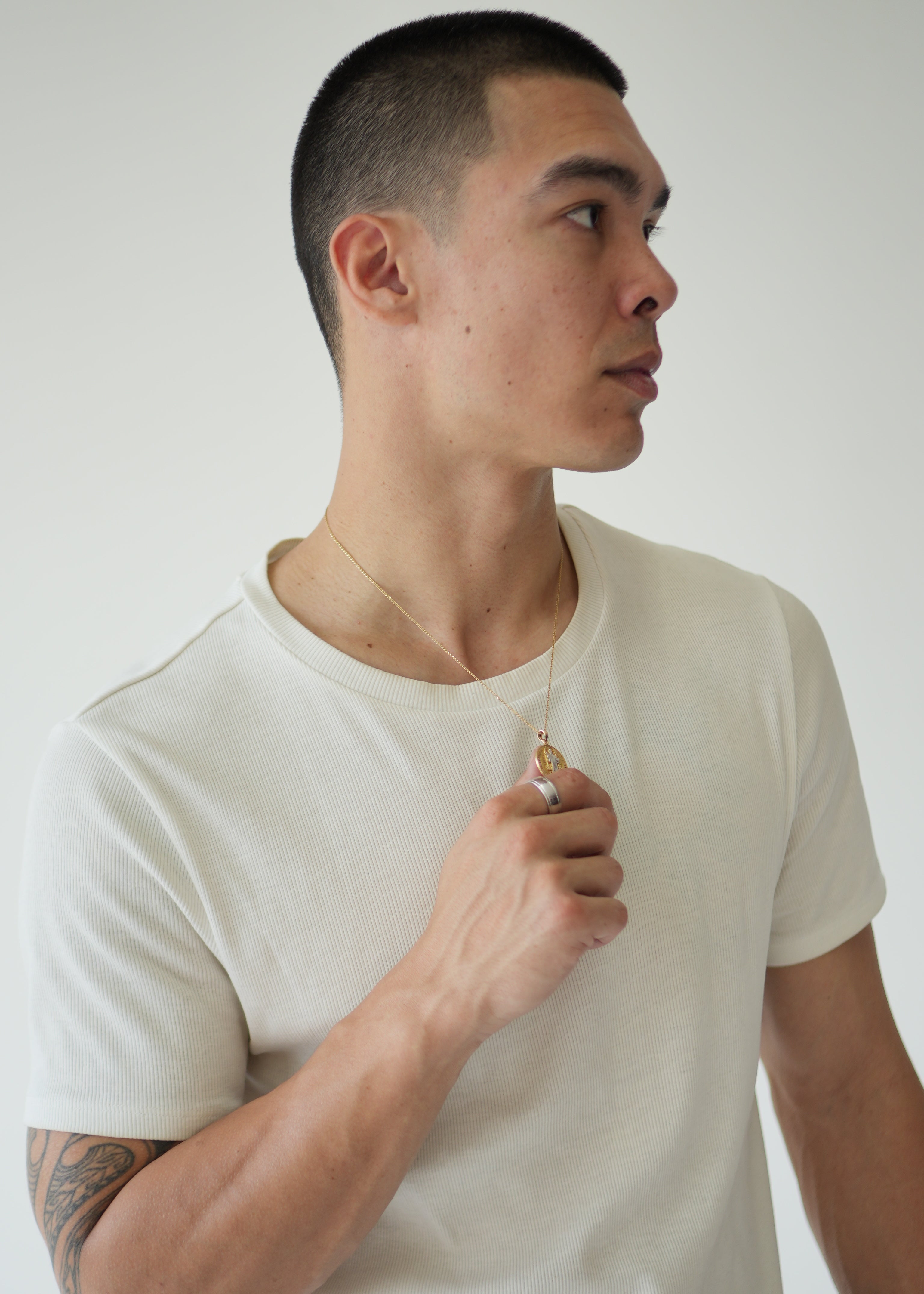 Person wearing a white tank top against a plain background