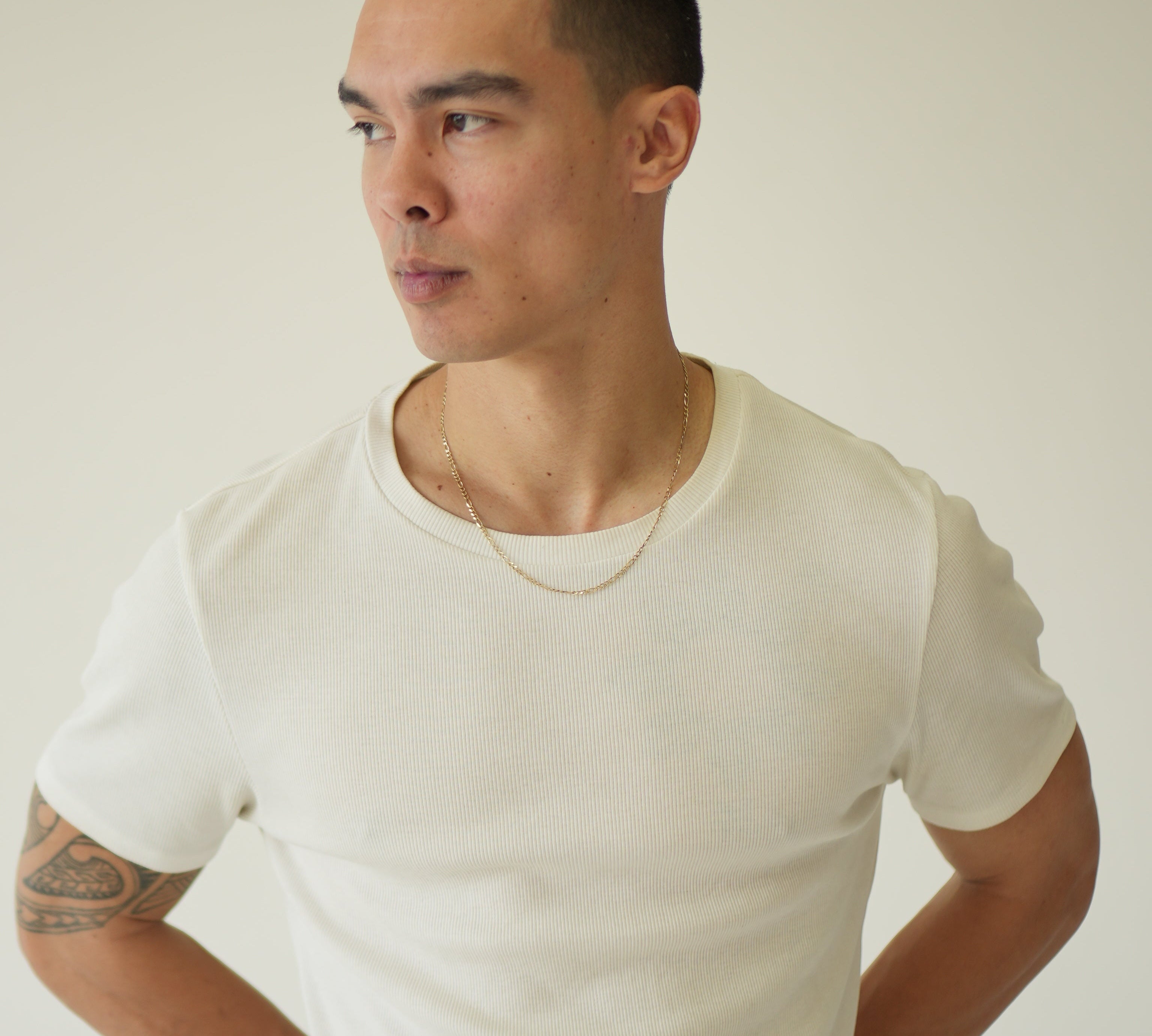 Person wearing a white shirt against a plain background