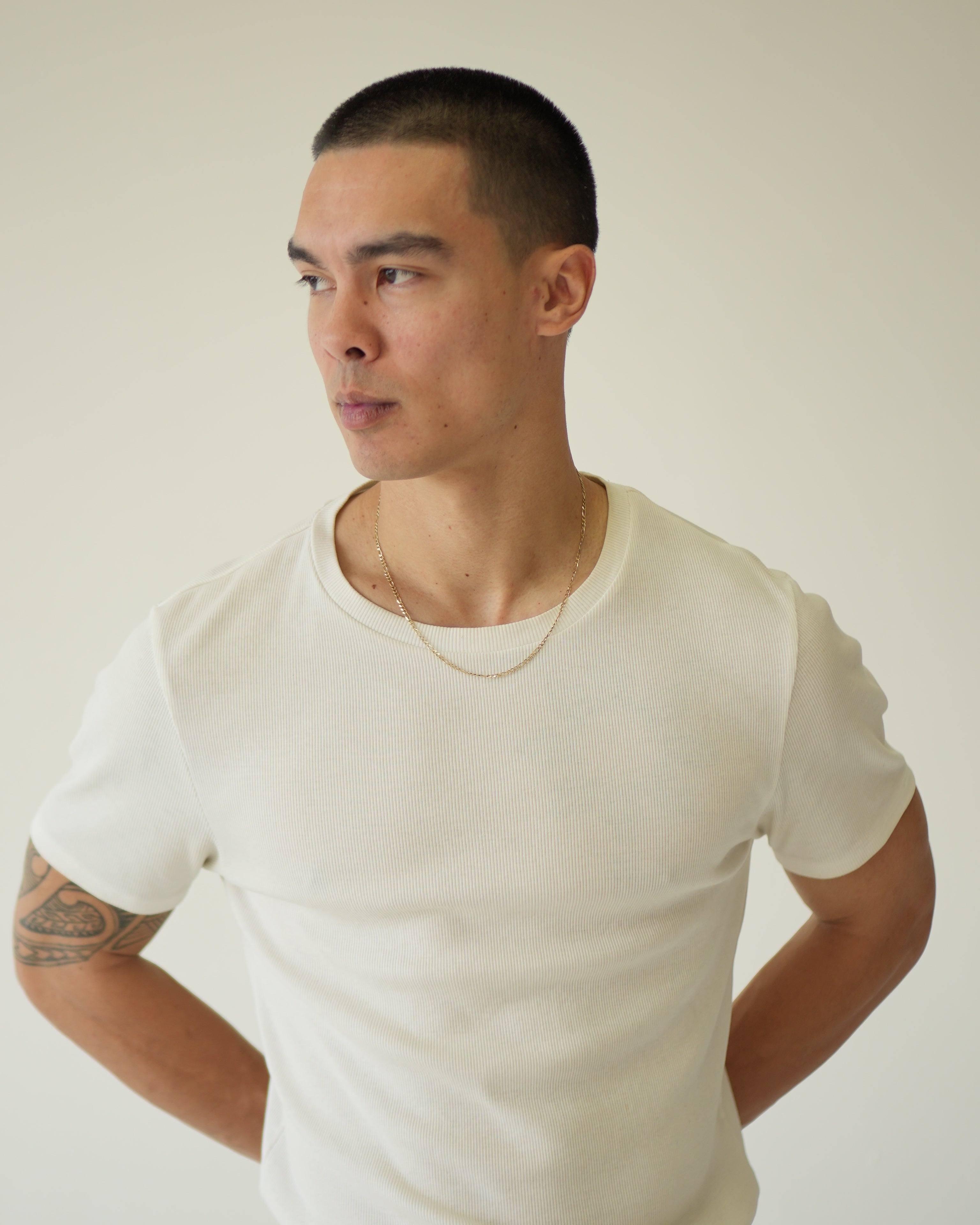 Person wearing a white shirt against a plain background