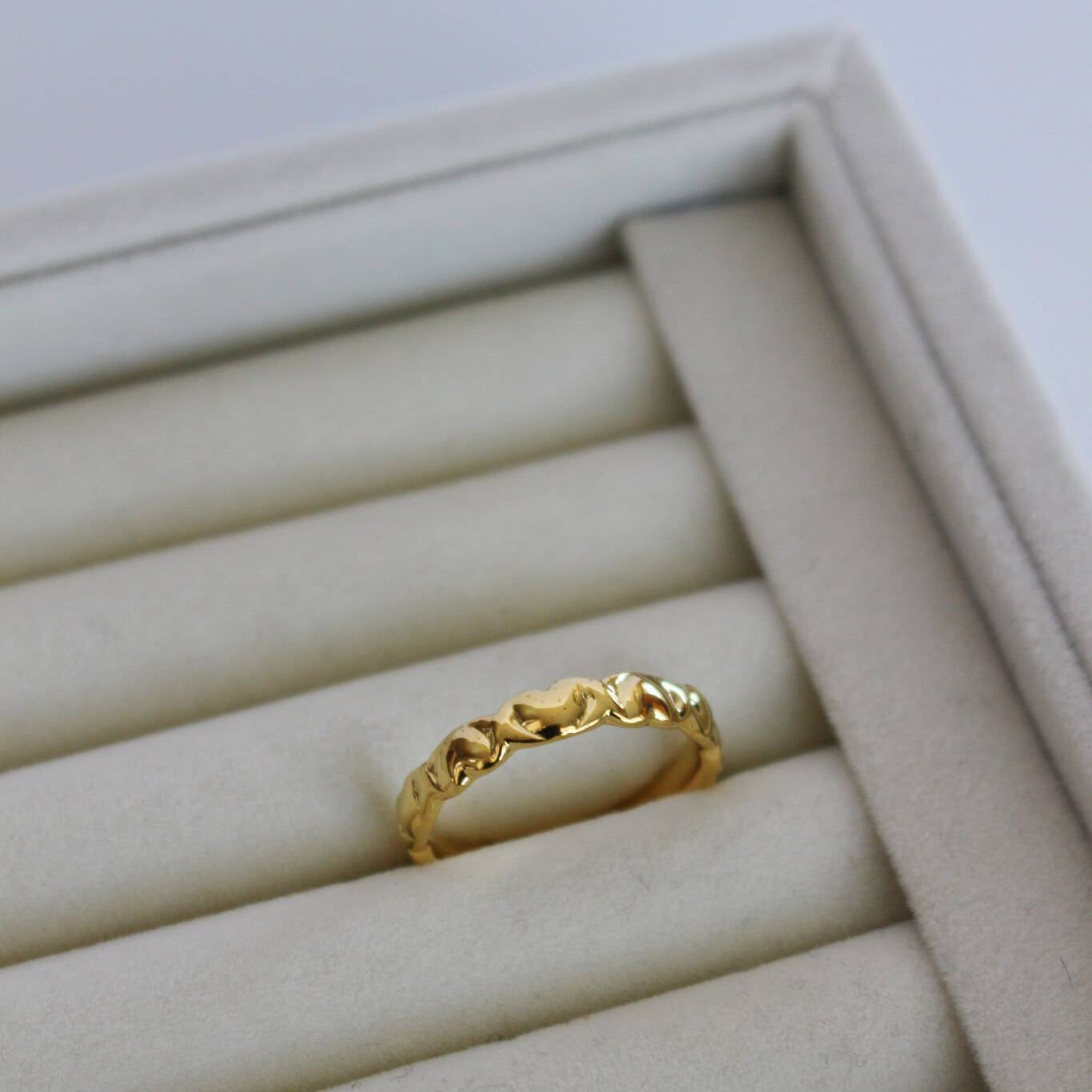 image of a gold heart ring on a ring tray on top of a marble table