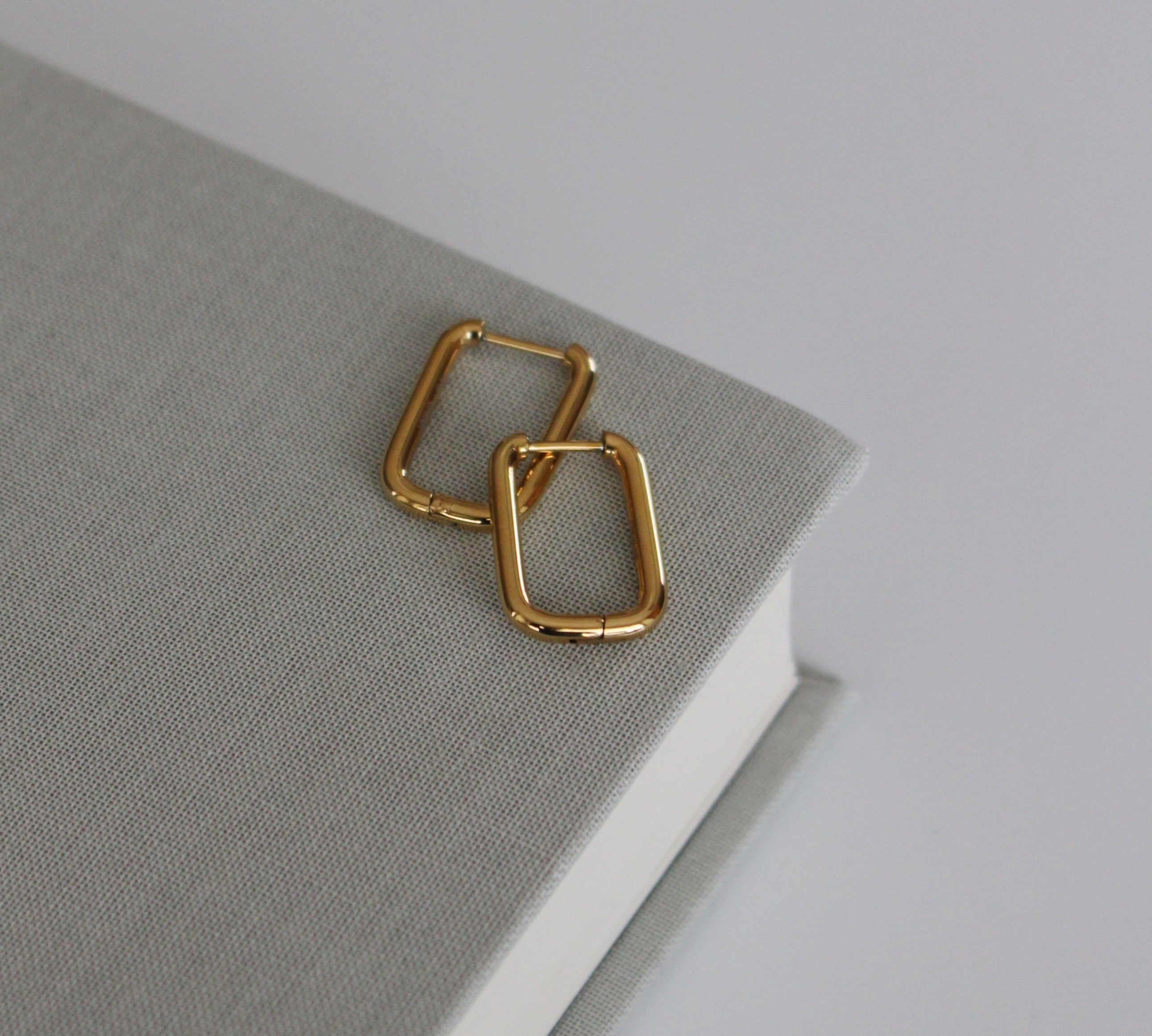 image of gold square hoops on top of a book