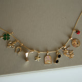 Gold necklace with various charms on a beige background