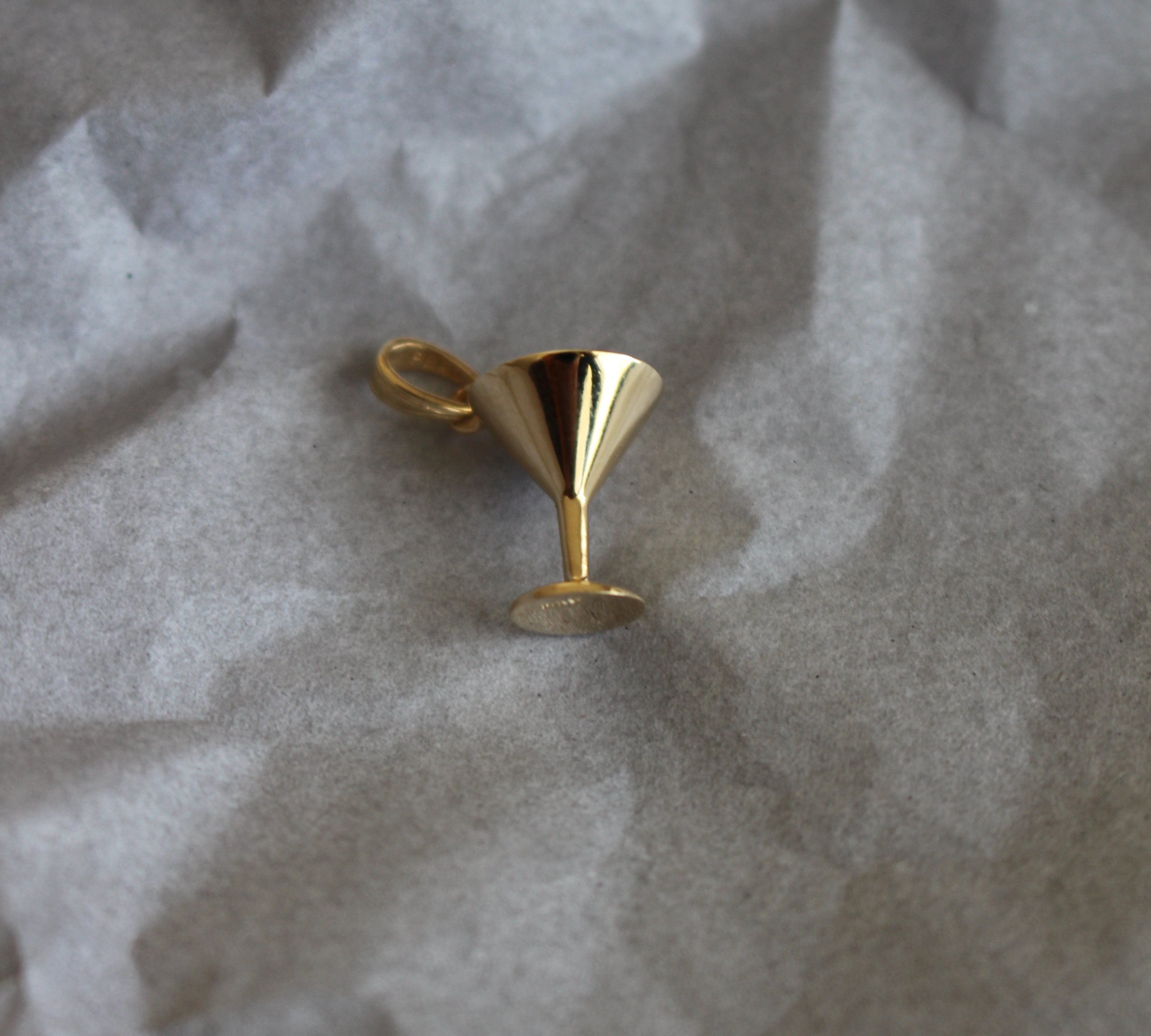 gold martini glass on gray paper