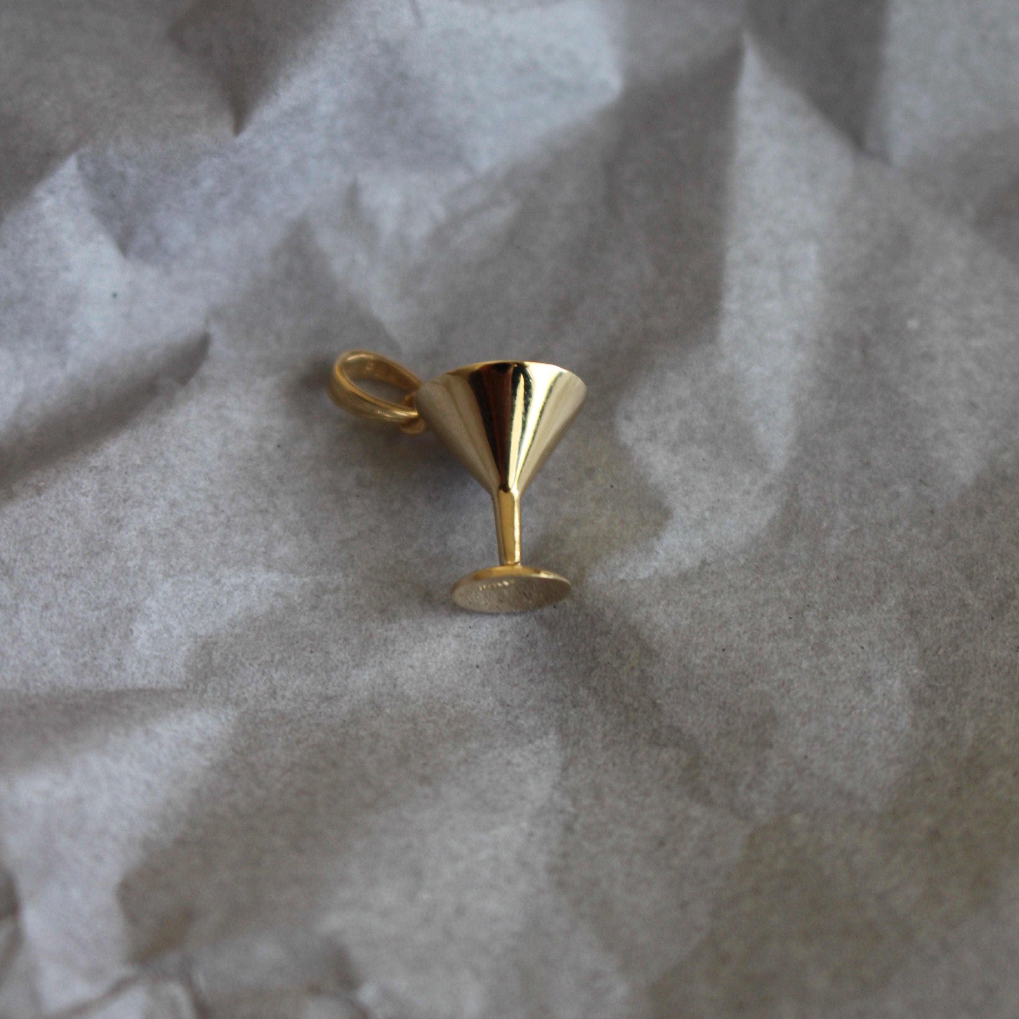 gold martini glass on gray paper