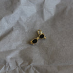 Gold and black earring on crumpled paper