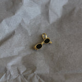 Gold and black earring on crumpled paper