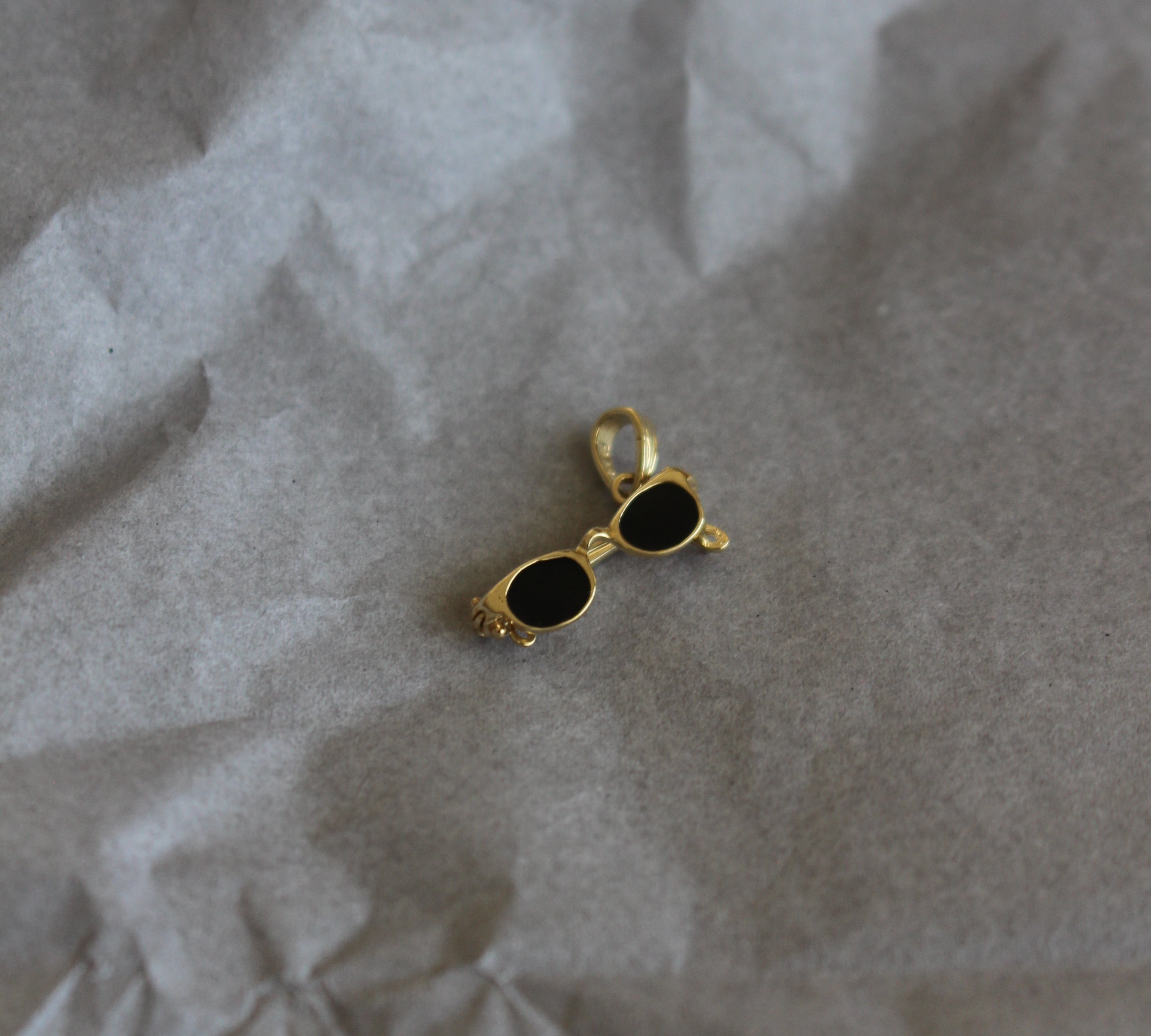 Gold and black earring on crumpled paper