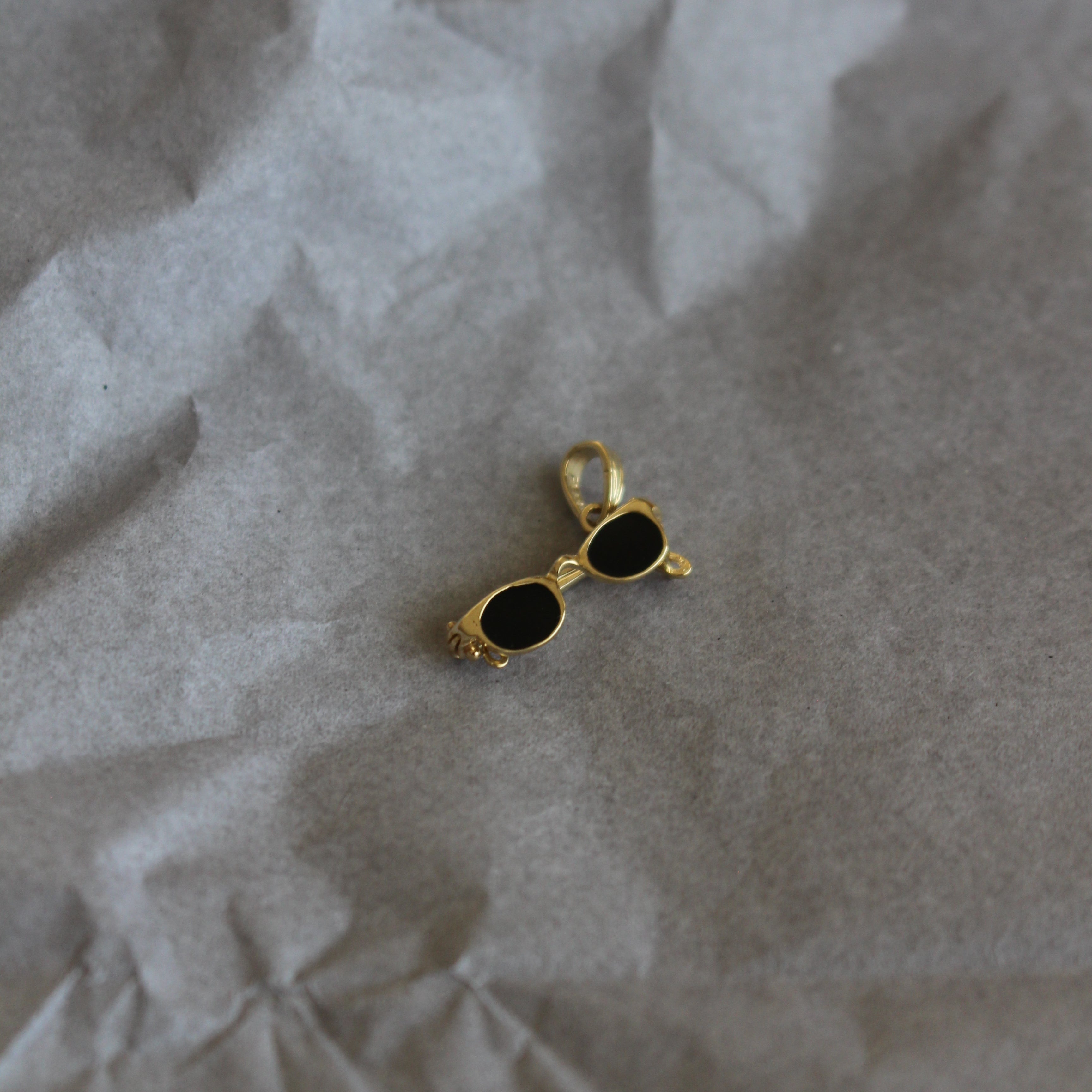 Gold and black earring on crumpled paper