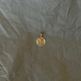 Gold pendant on crumpled paper