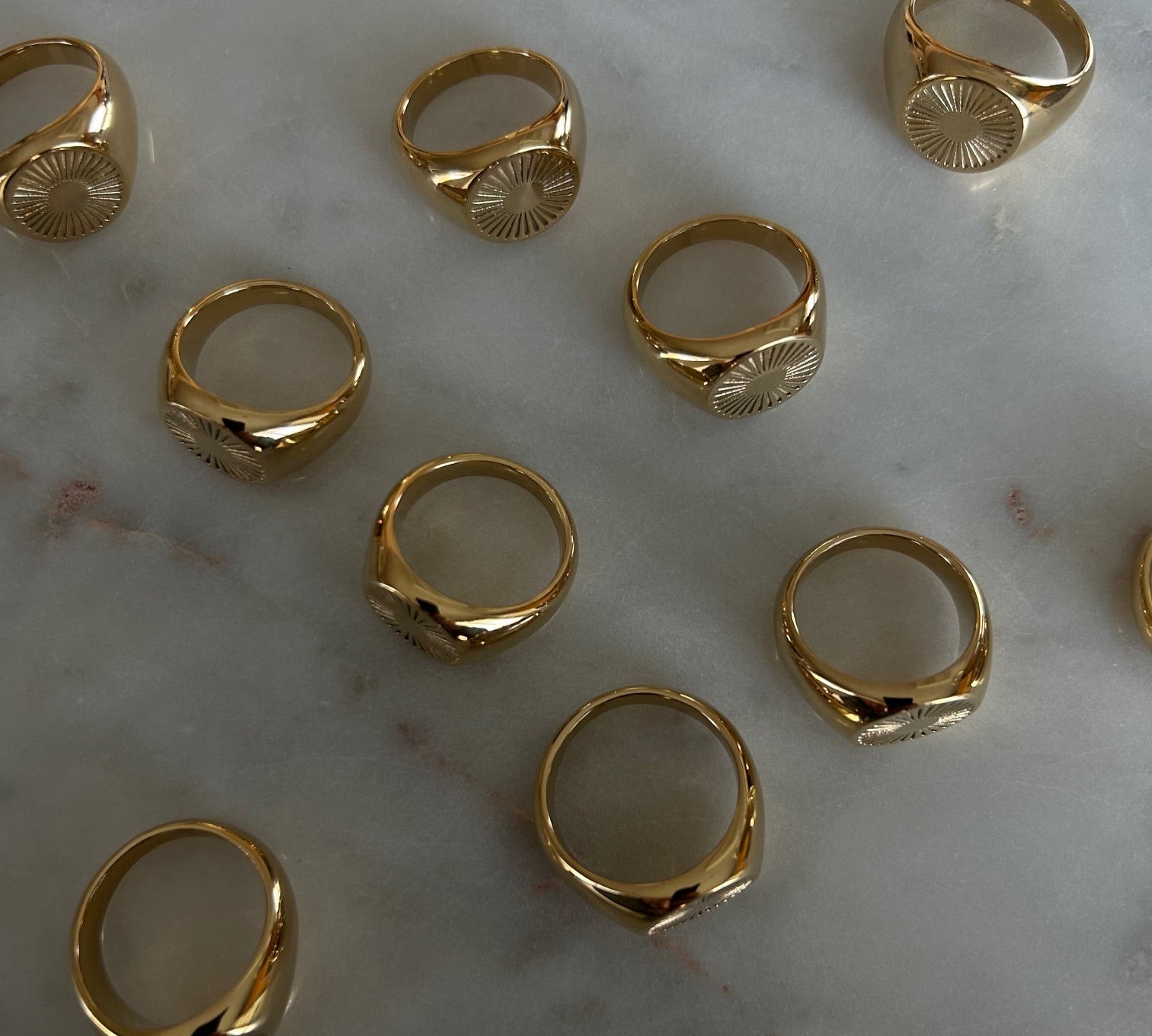 image of gold signet rings on a marble table