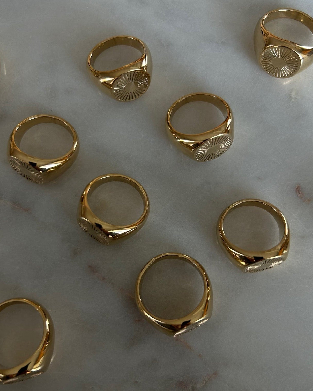 image of gold signet rings on a marble table