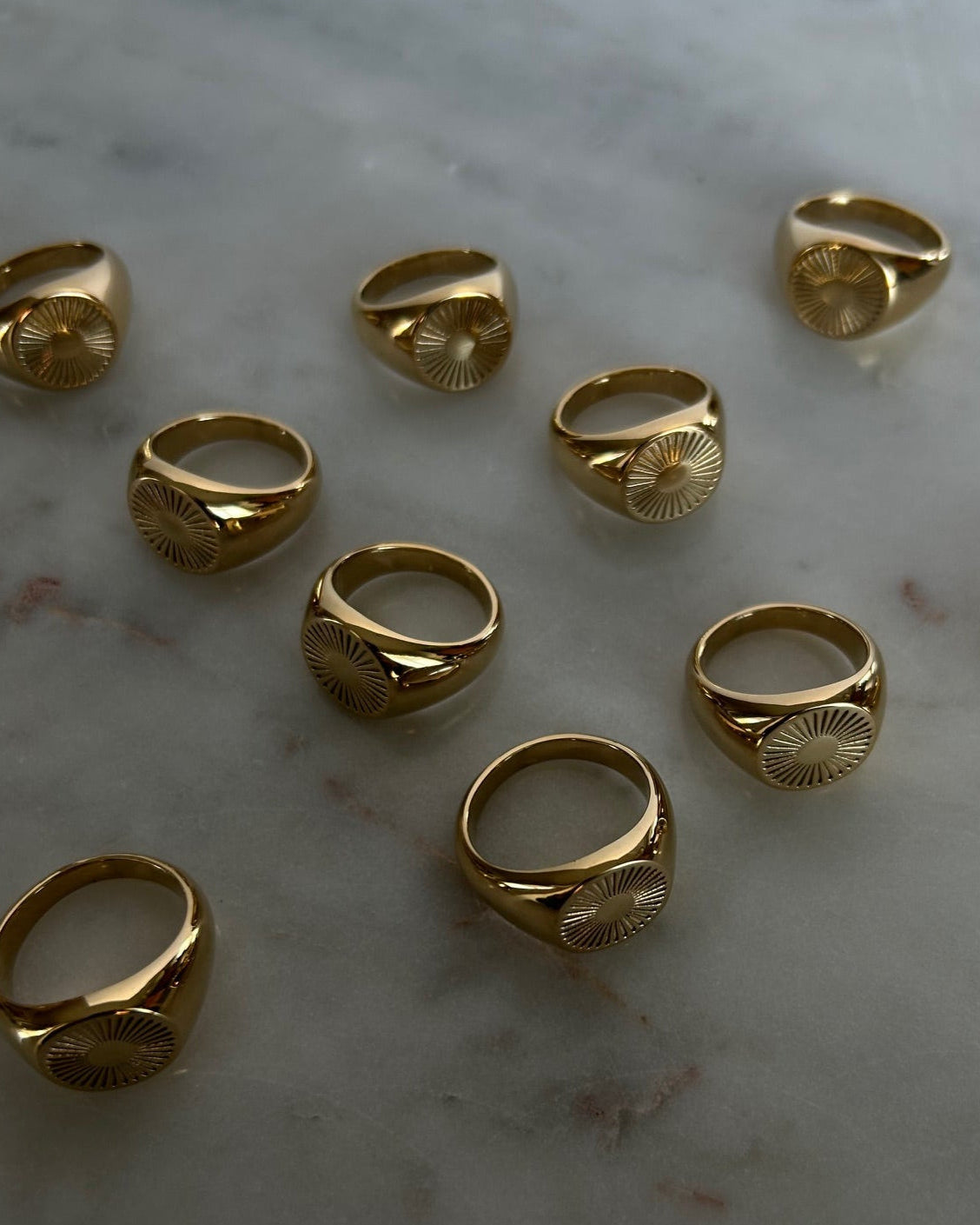 image of gold signet rings on a marble table