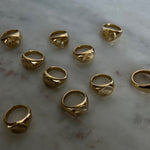 image of gold signet rings on a marble table
