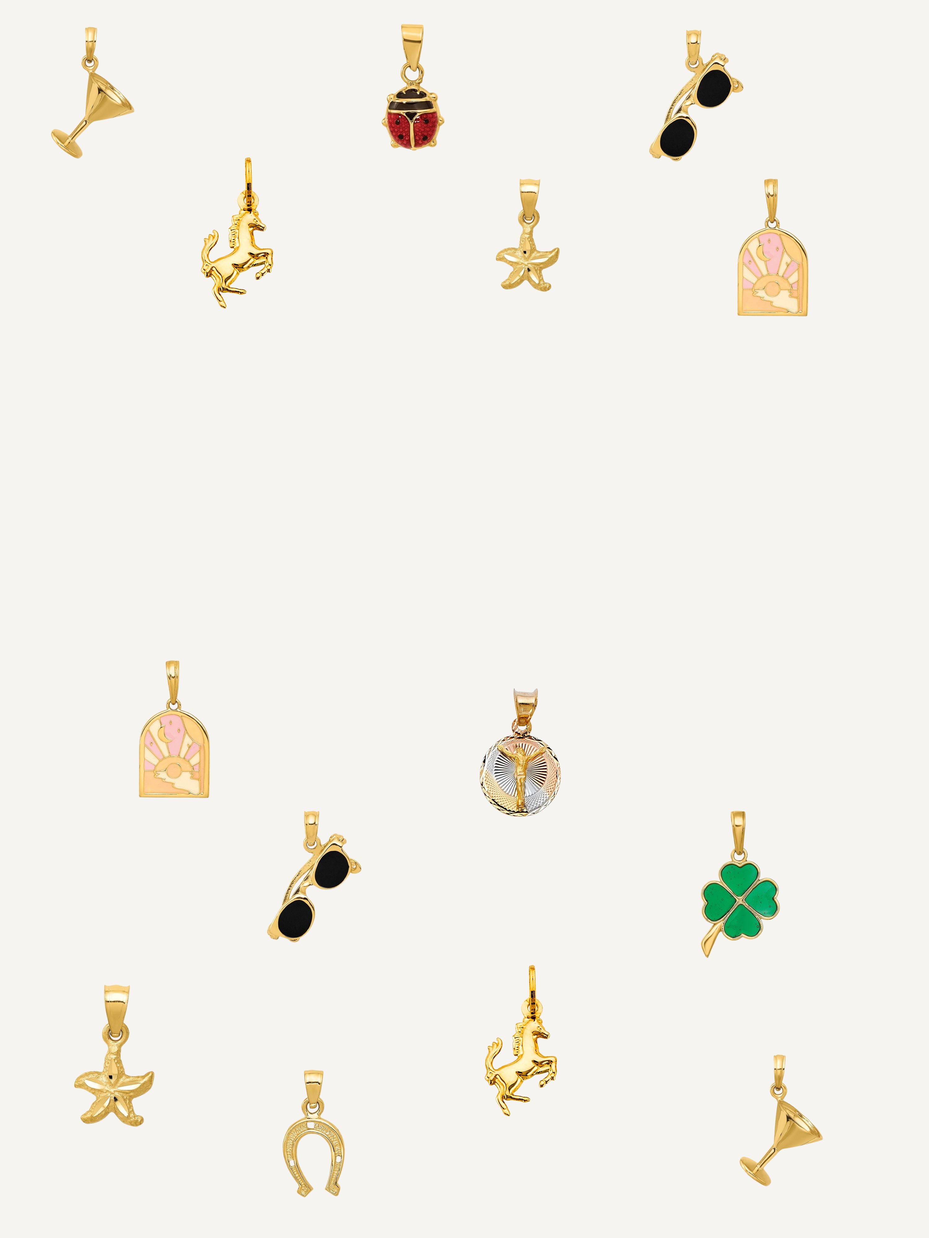 Collection of various gold and silver jewelry charms on a white background
