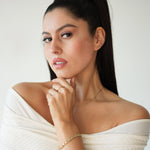 Woman wearing a white off-shoulder top with a plain background