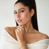 Woman wearing a white off-shoulder top with a plain background