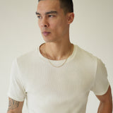 Man wearing a white t-shirt against a plain background