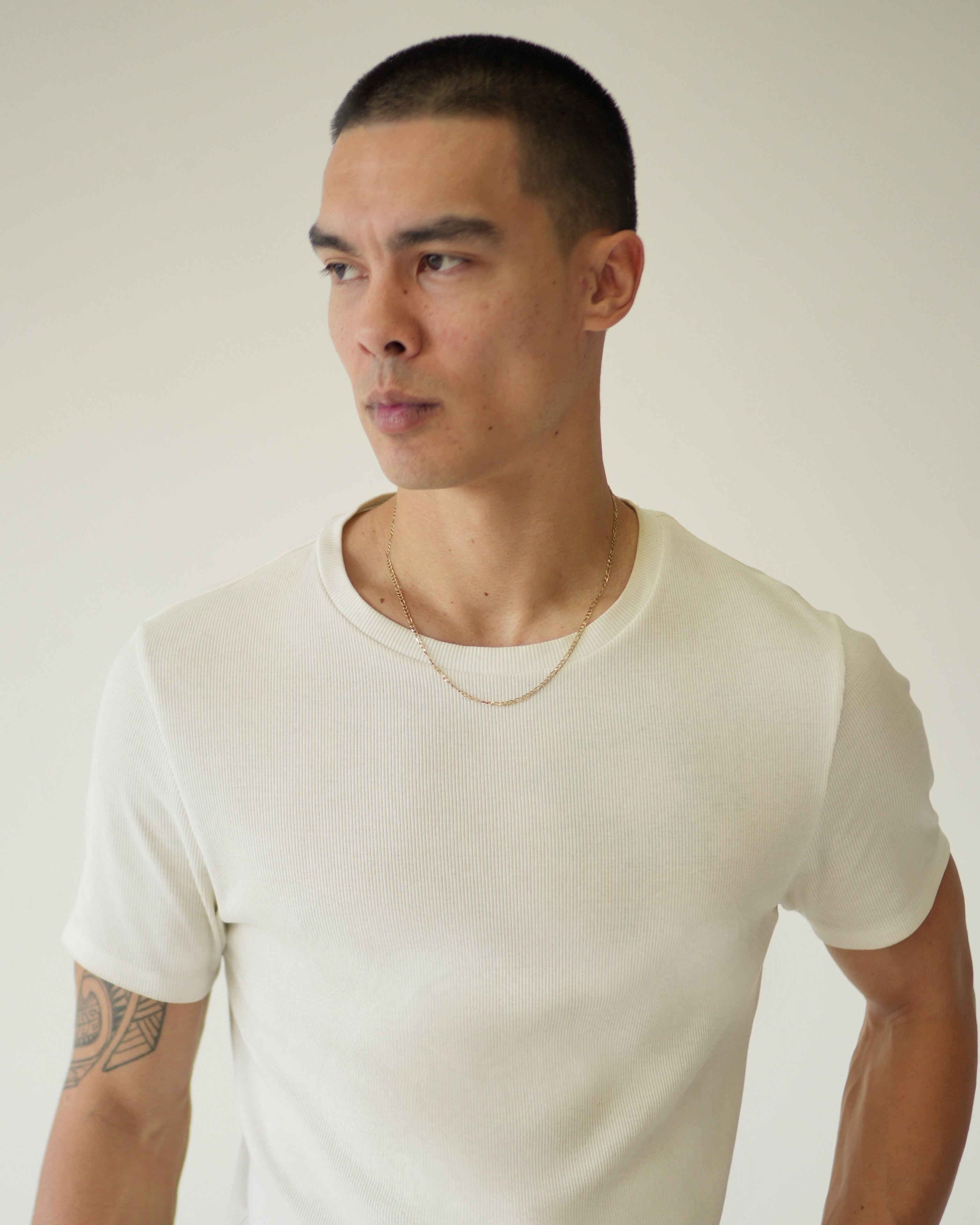 Man wearing a white t-shirt against a plain background
