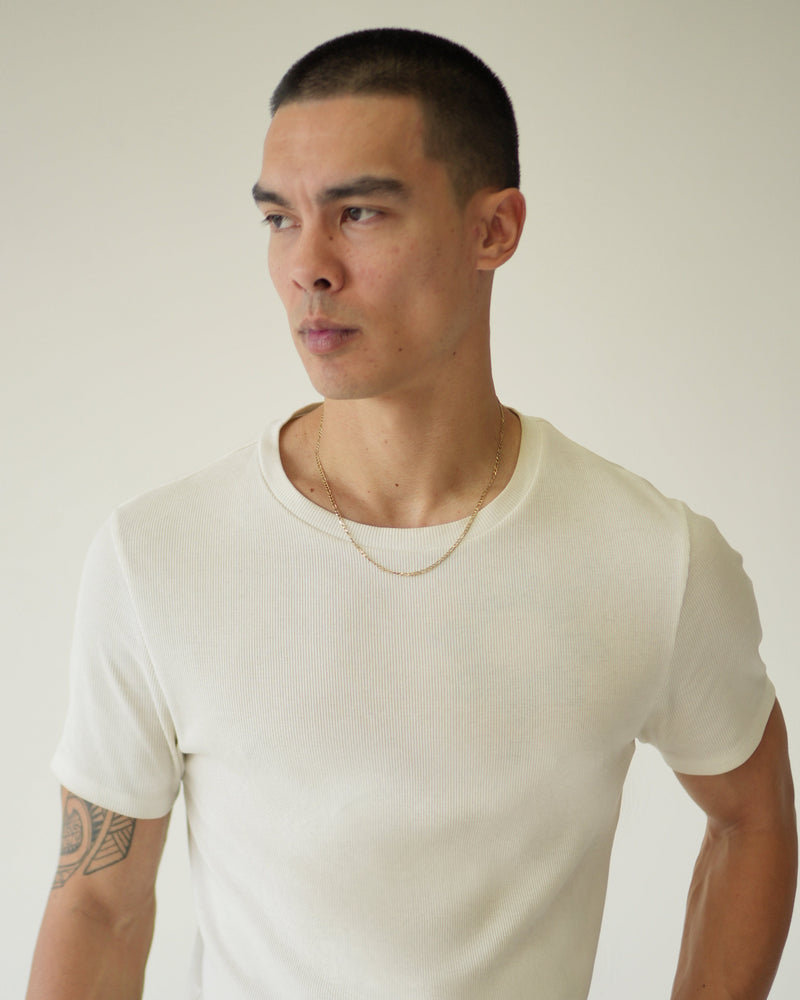 Man wearing a white t-shirt against a plain background
