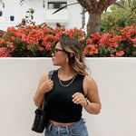 woman looking to the side wearing gold teardrop earrings and a paperclip bracelet 