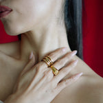 Close-up of a woman's hand with gold rings on a red background