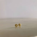 image of two diamond cut ball stud earrings on a marble table