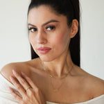 Woman wearing gold jewelry against a white background