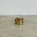 Gold ring on a reflective surface with a light gray background