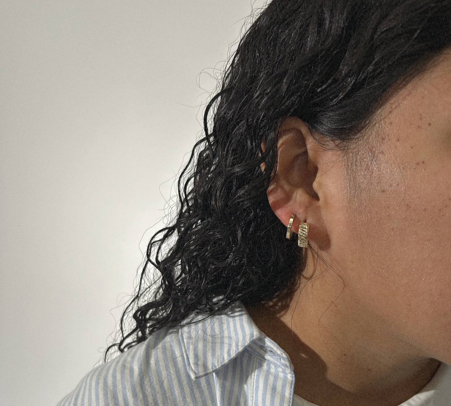 woman wearing two gold hoops 