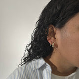 woman wearing two gold hoops 