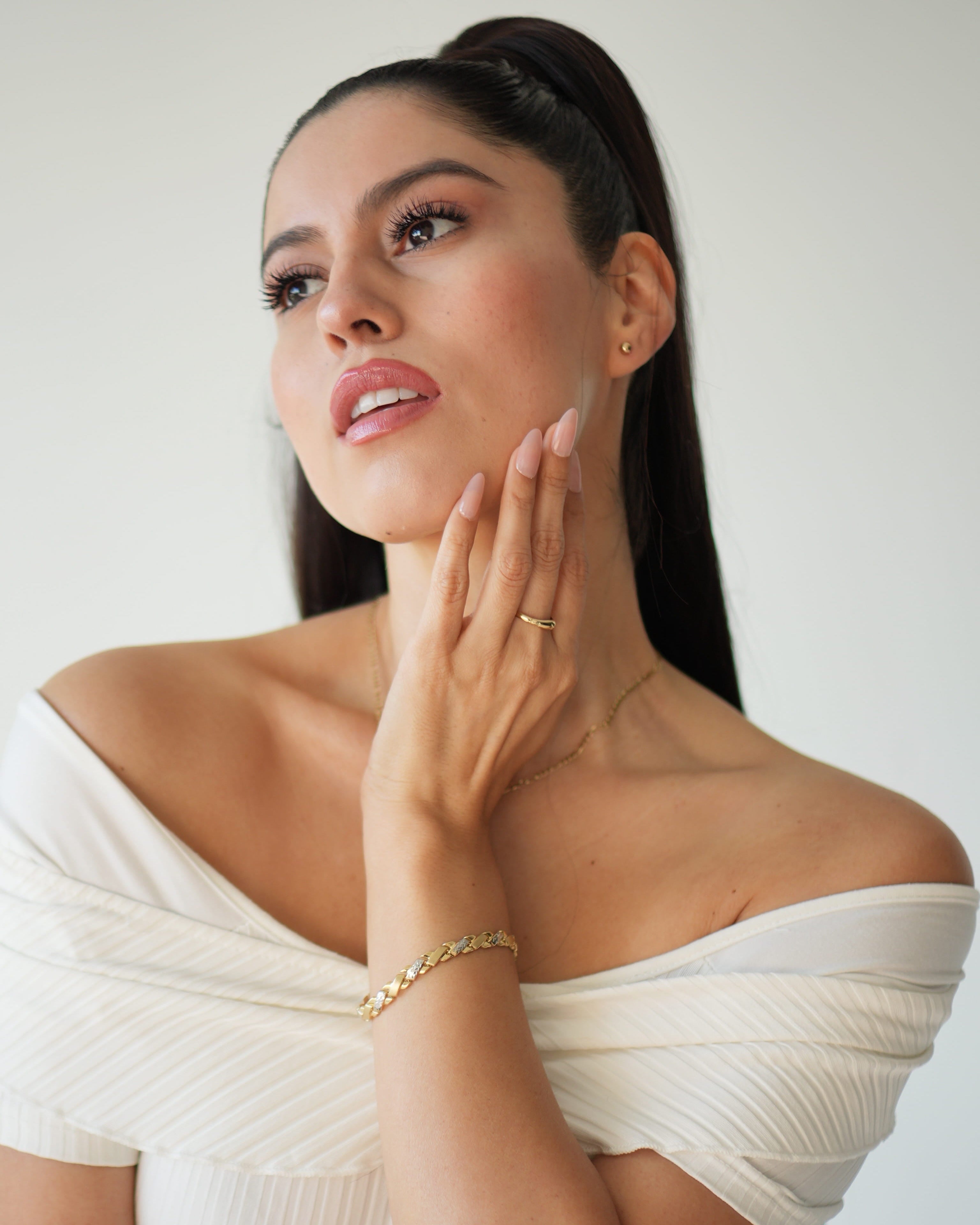 Woman in a white off-shoulder top with a neutral background