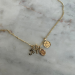 charm pendants on a necklace against a marble backdrop