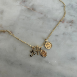 charm pendants on a necklace against a marble backdrop