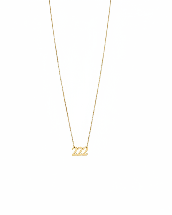 Gold necklace with '222' pendant on a white background