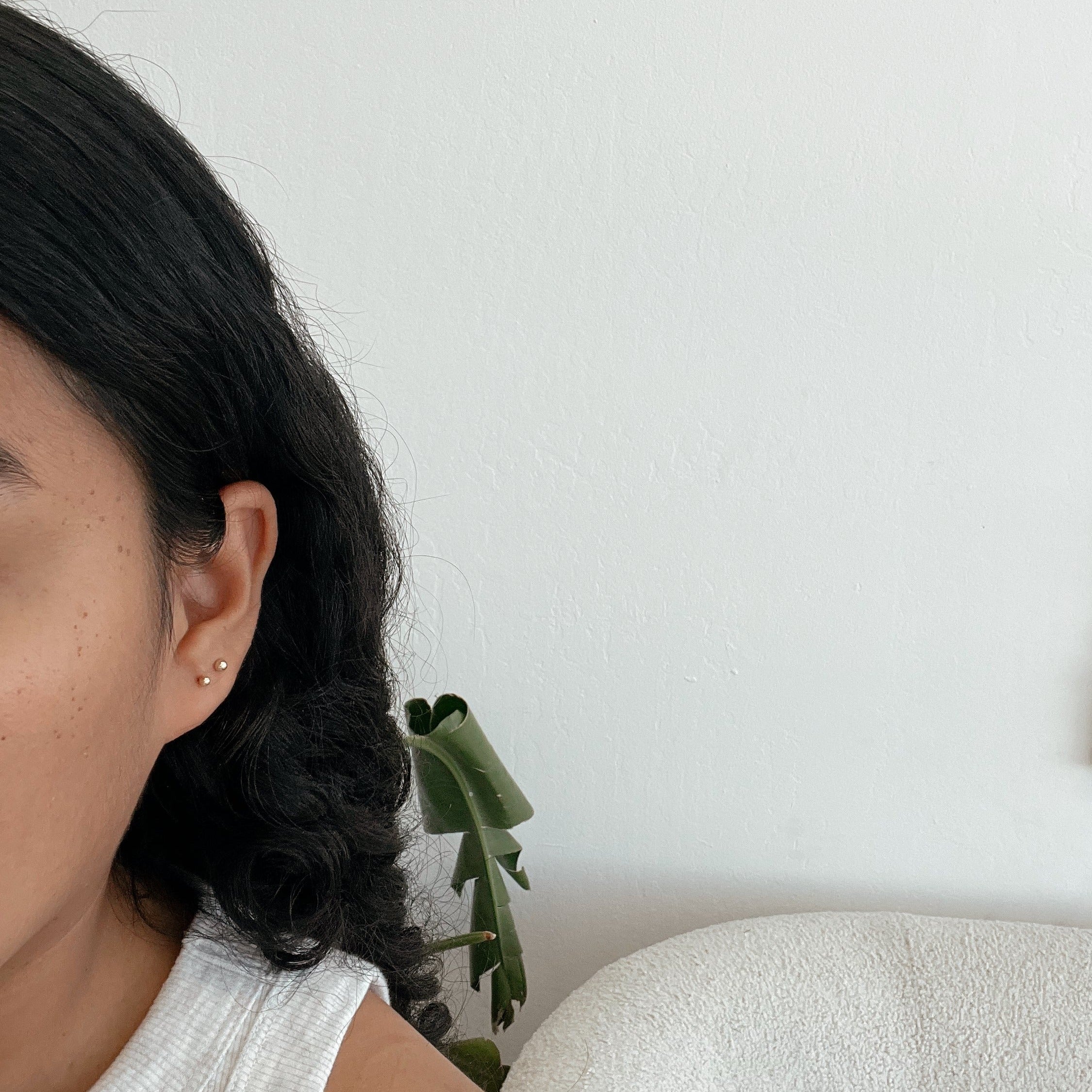 image of a woman taking a selfie with 14K ball studs 