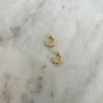 image of gold earrings on a marble table